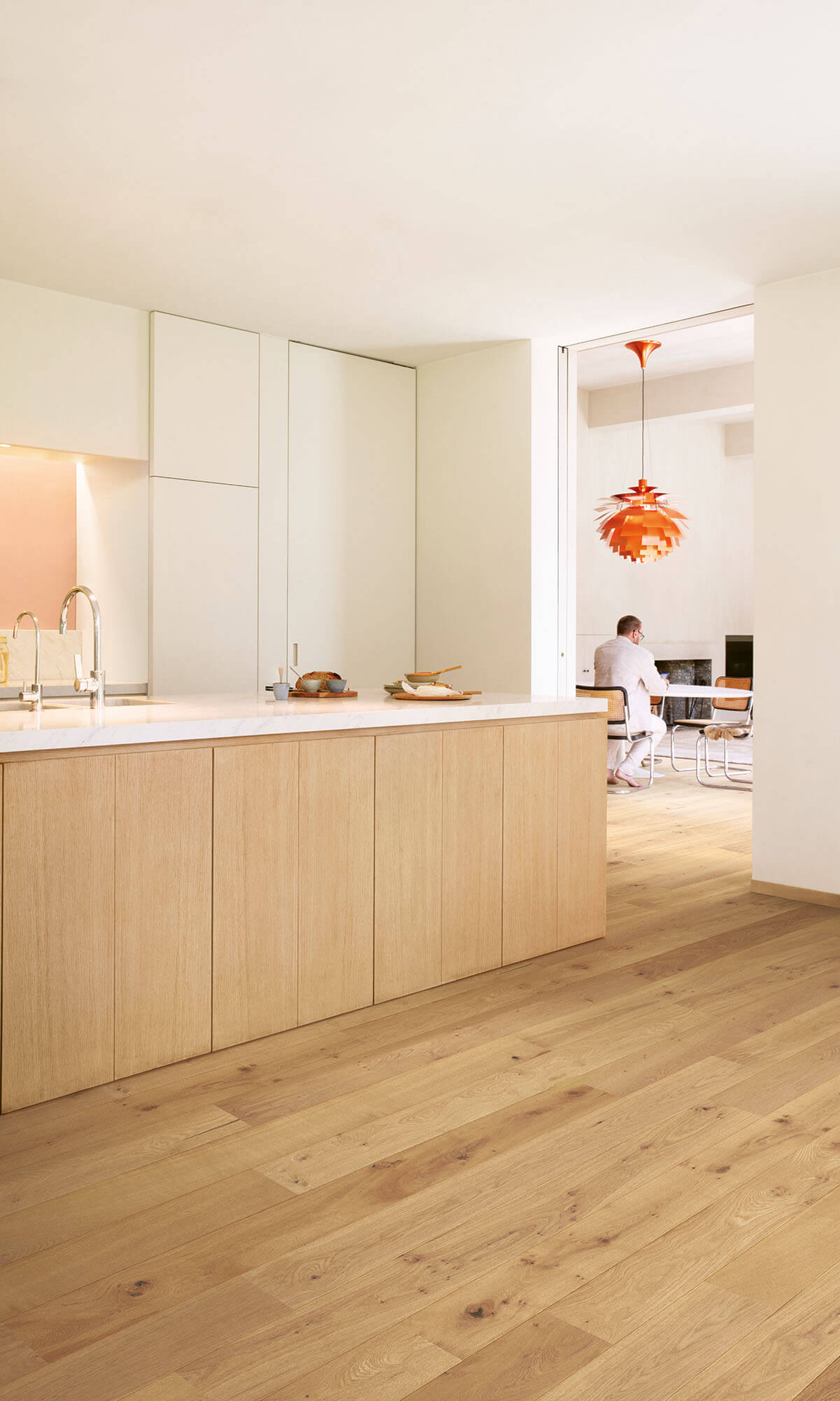 Modern kitchen with wooden flooring and white cabinets