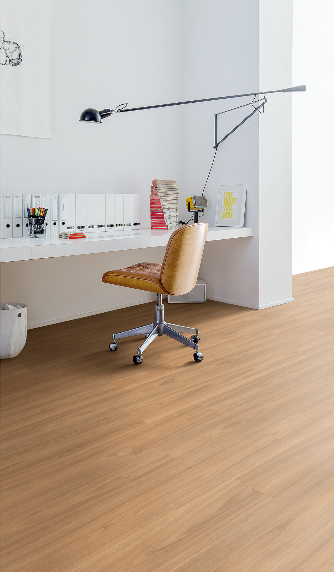 Modern office chair in a minimalistic office setting with a desk and lamp.