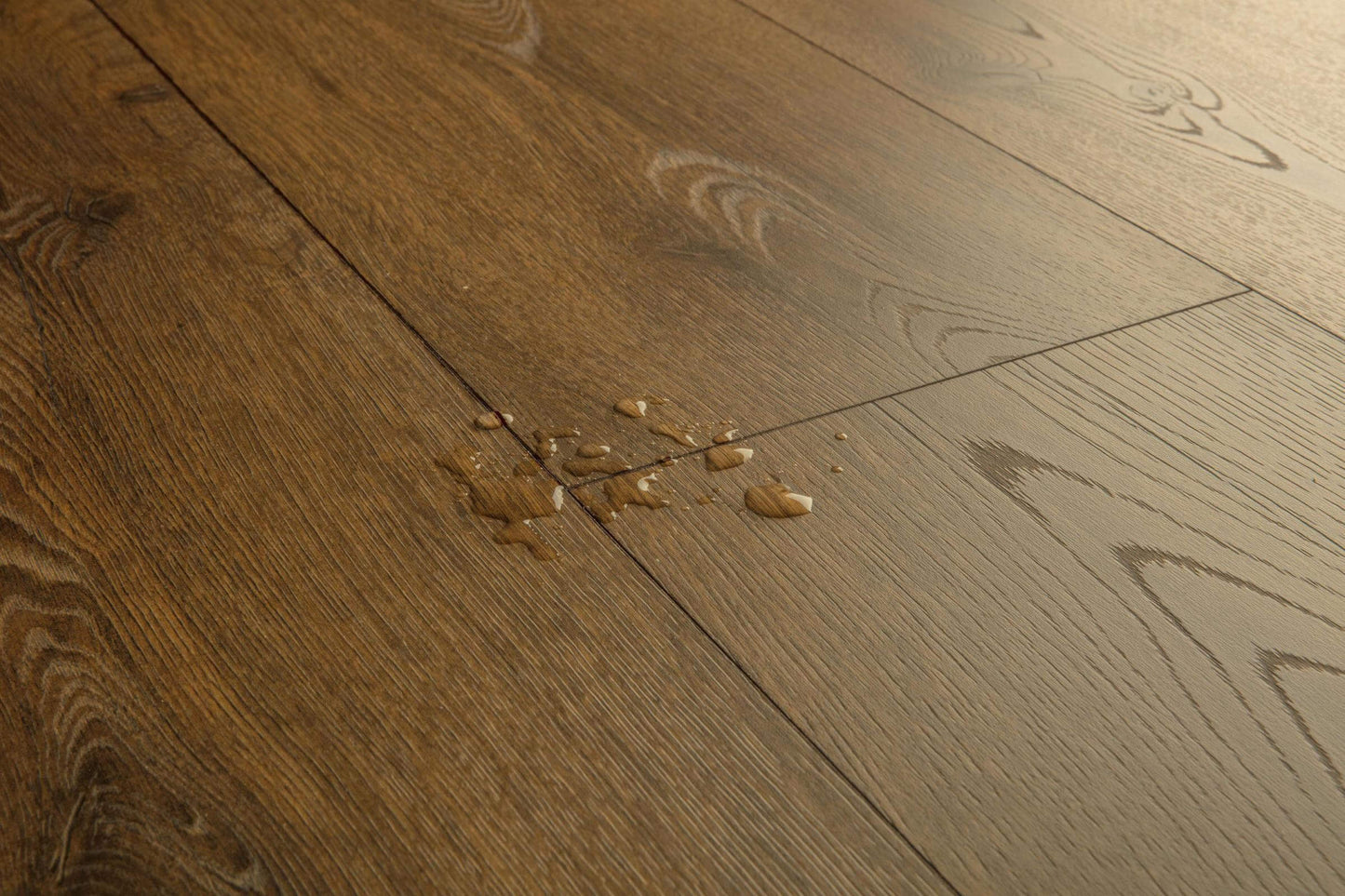 Wooden floor with a small water spill on a wooden surface