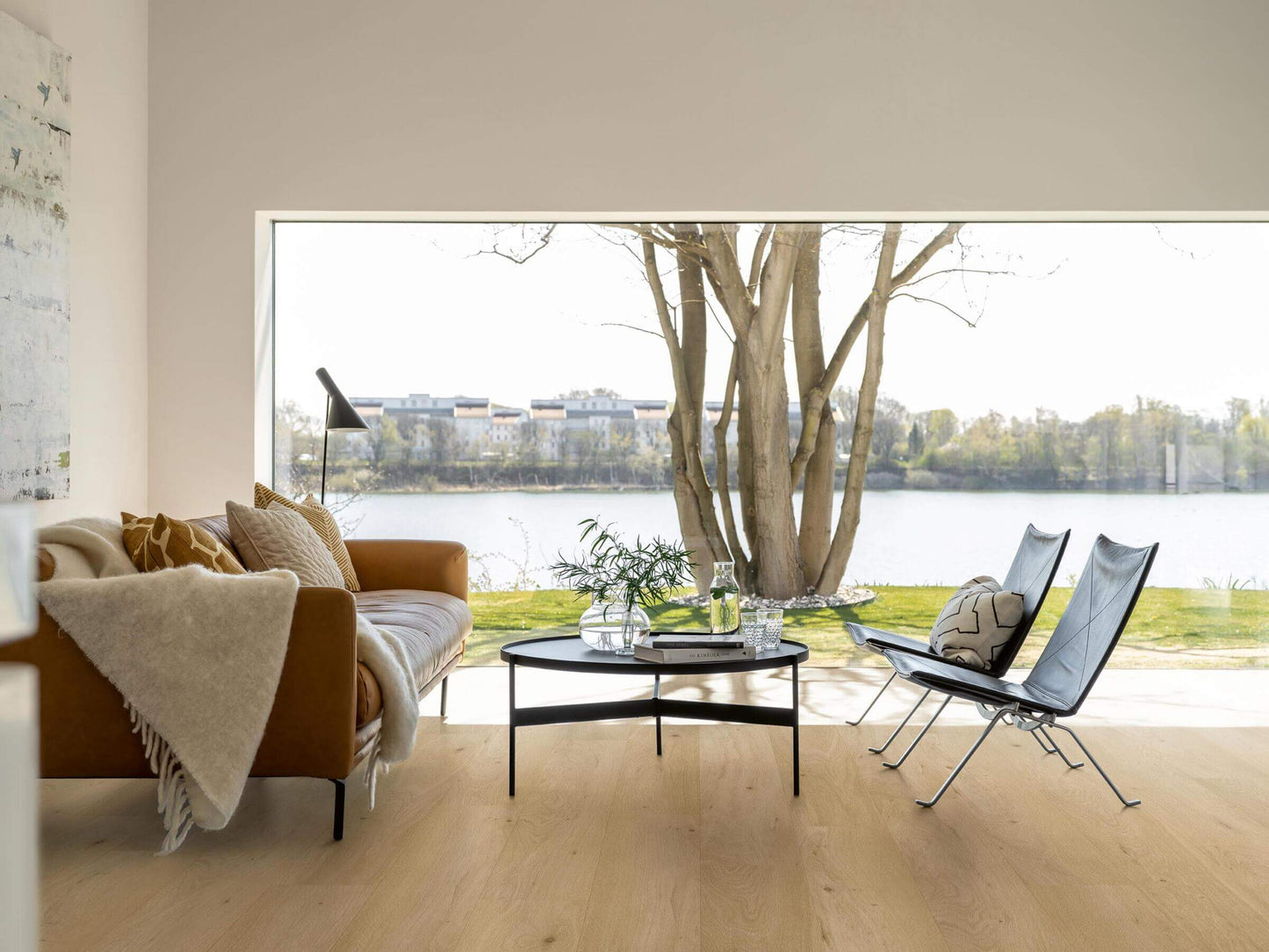 Modern living room with a view of a lake and trees