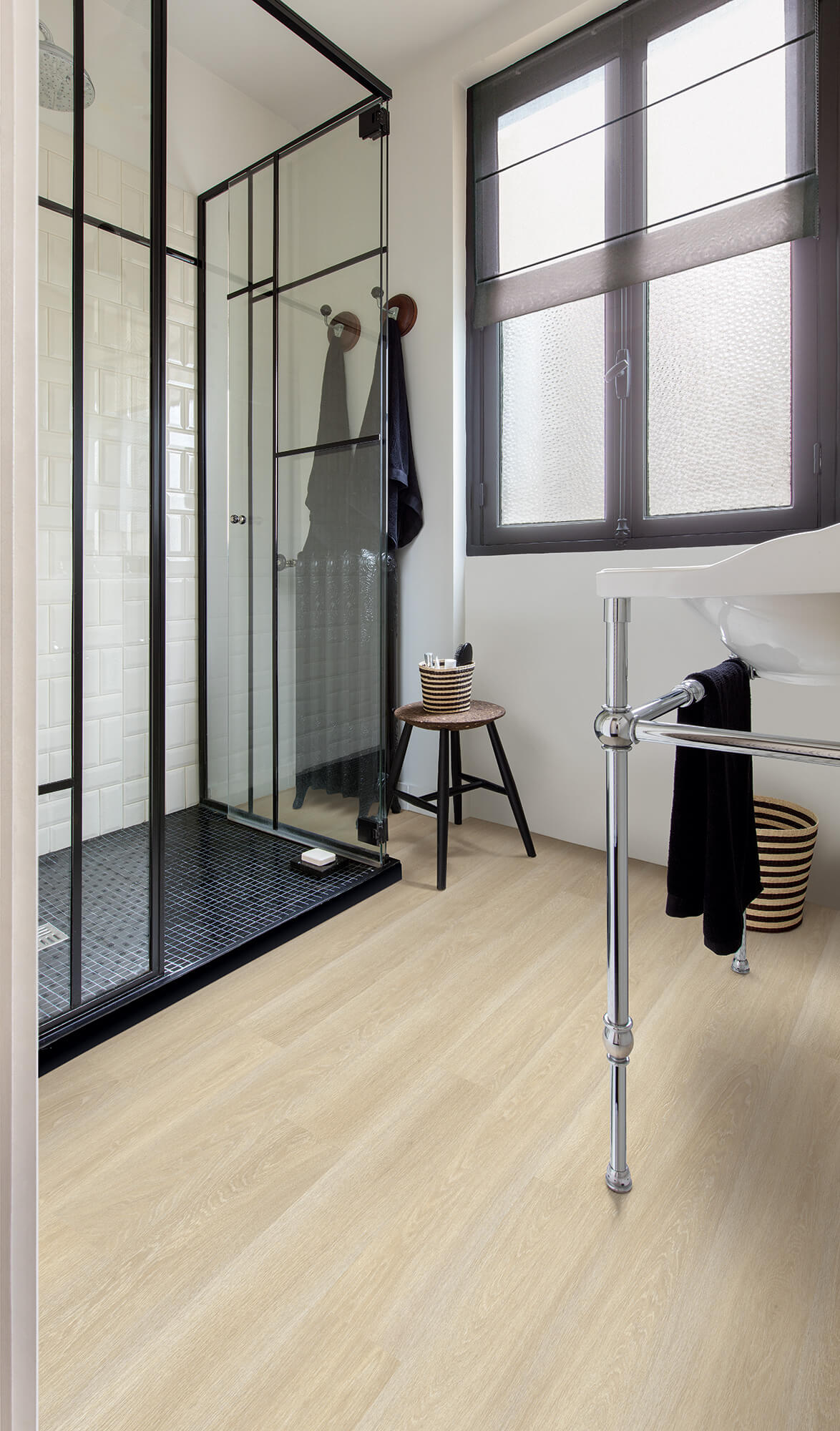 Bathroom interior with shower enclosure, towel rack, and window.