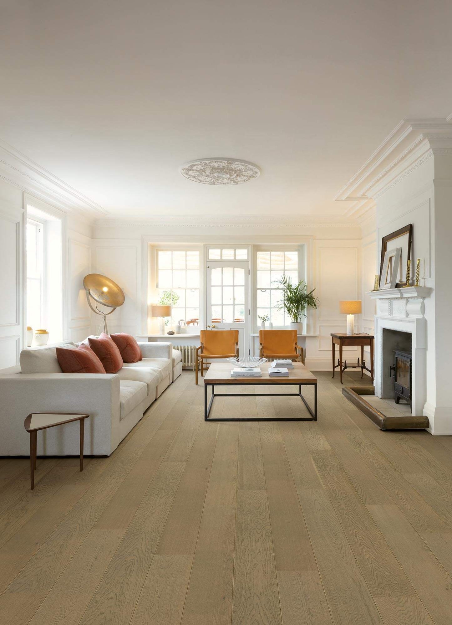 Living room with wooden flooring, white walls, and a fireplace.