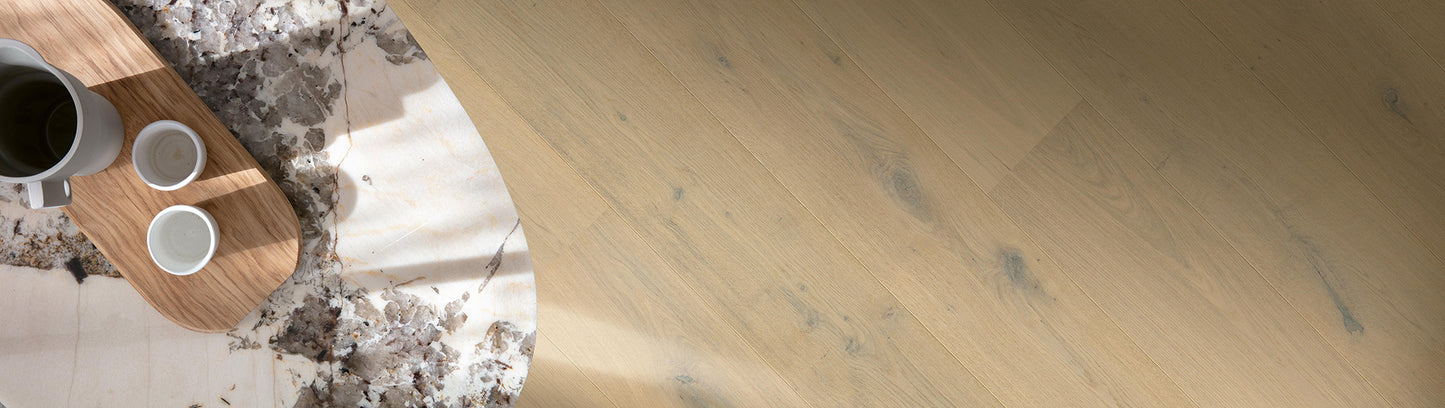 Wooden surface with a cutting board and cups, marble countertop in the background
