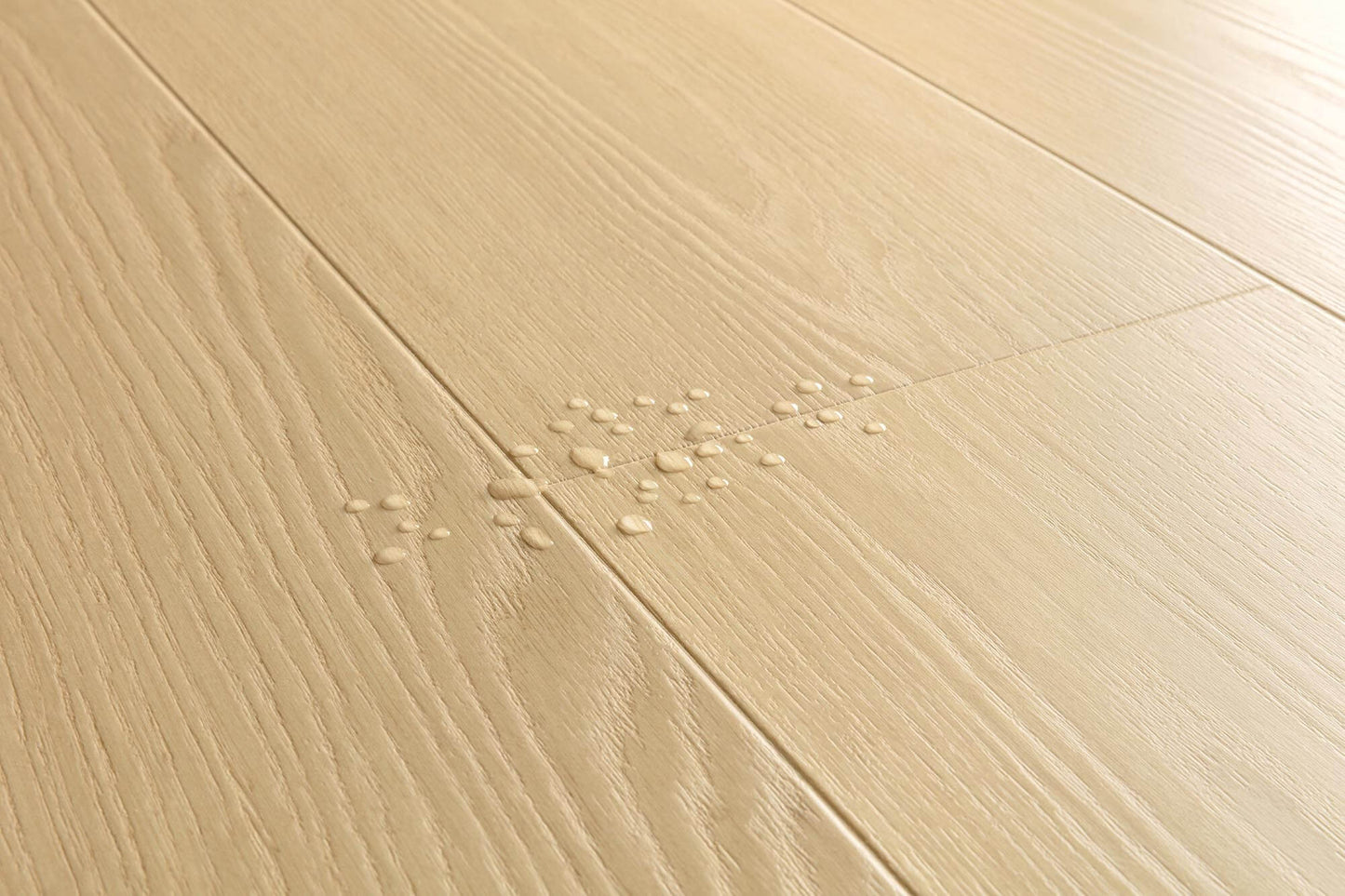 Light beige wood-look floor planks with visible grain texture and a small cluster of water droplets in the center.