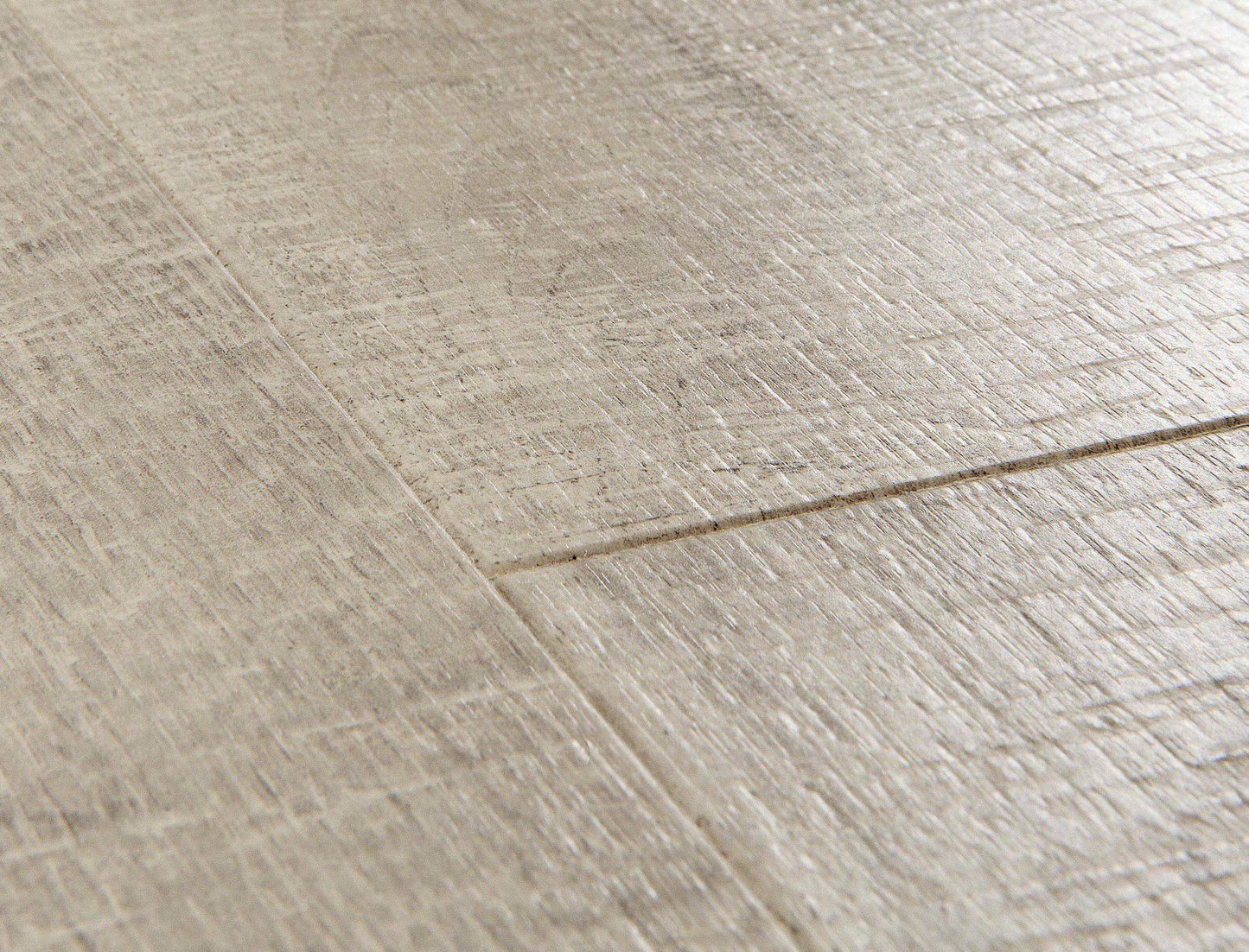 Close-up of a textured beige floor with a visible seam.