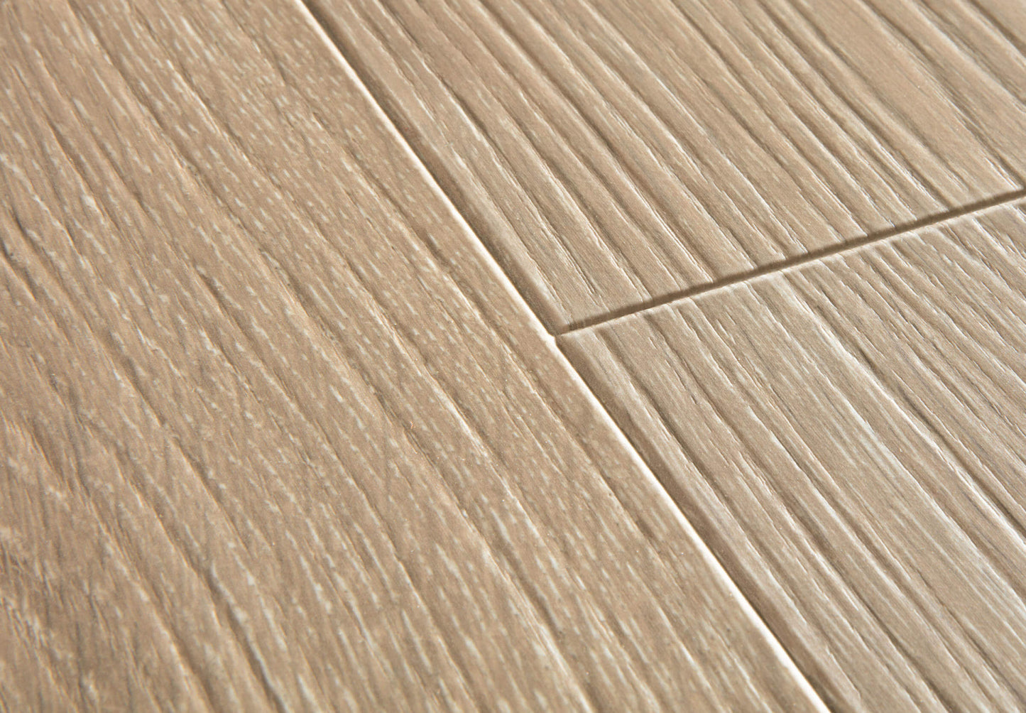 Close-up of beige ceramic tiles with a herringbone pattern