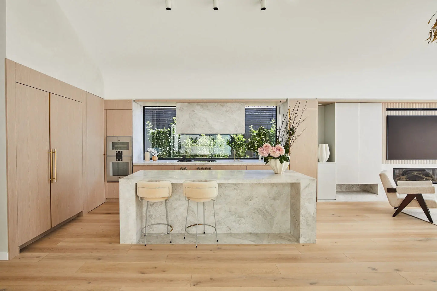 Modern kitchen with island and stools, featuring a neutral color palette.