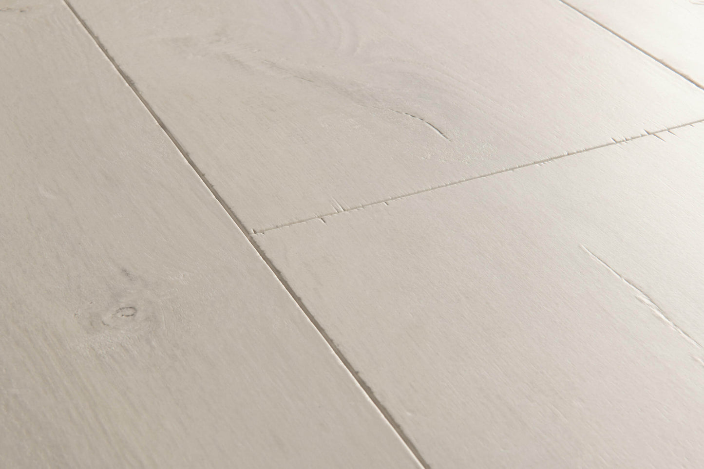 Close-up of a light gray wooden floor with a chevron pattern