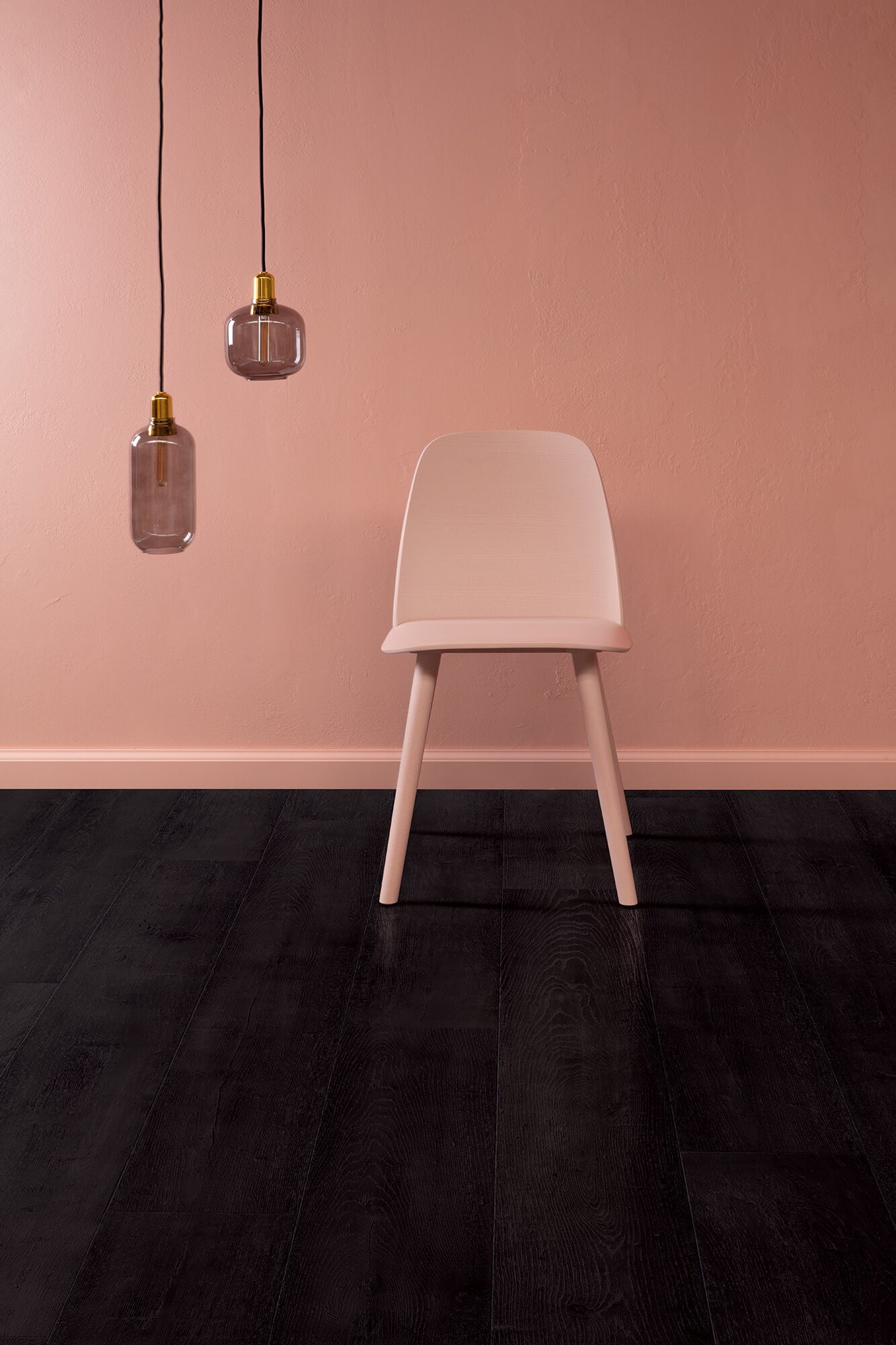Beige chair against a pink wall with two pendant lights.