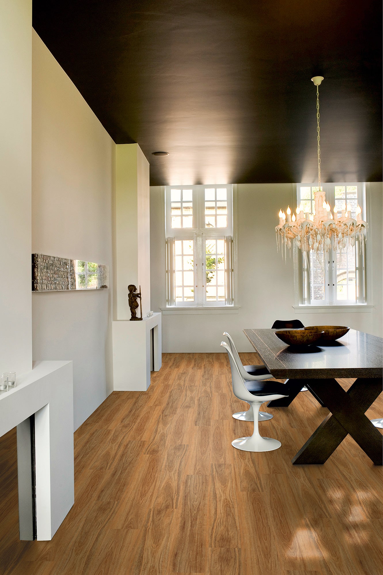 Modern dining room with wooden floor, white walls, and a chandelier.
