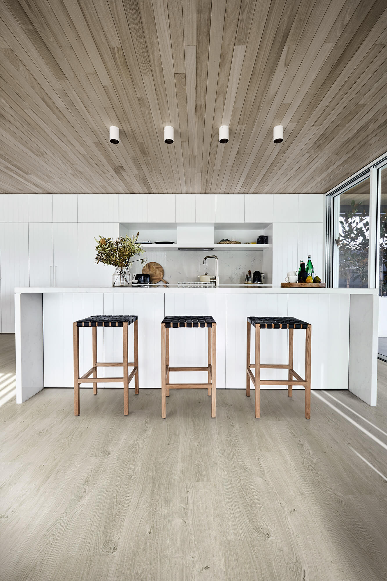 Modern kitchen with wooden stools and a white countertop