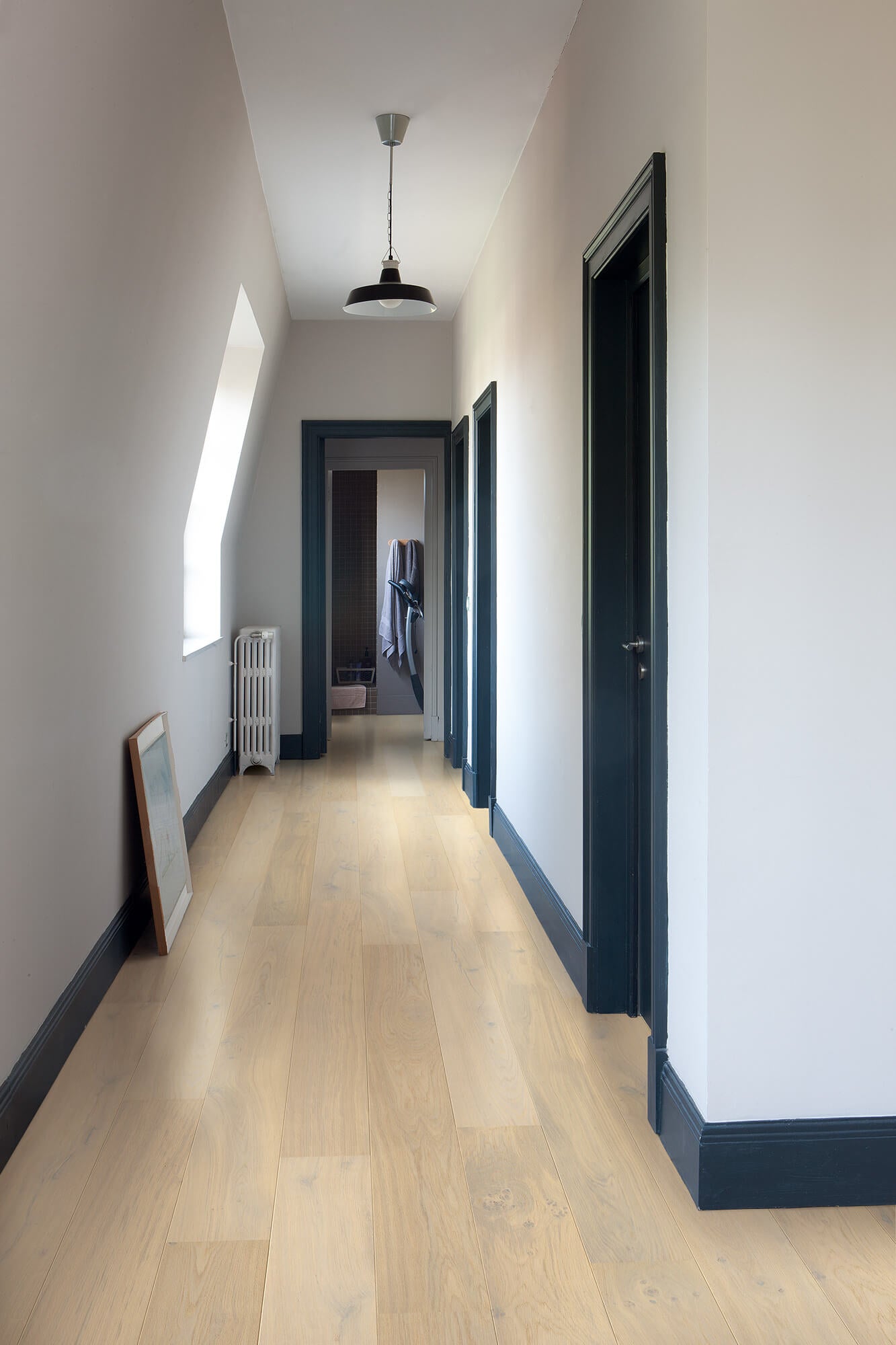 Long hallway with wooden floor and white walls