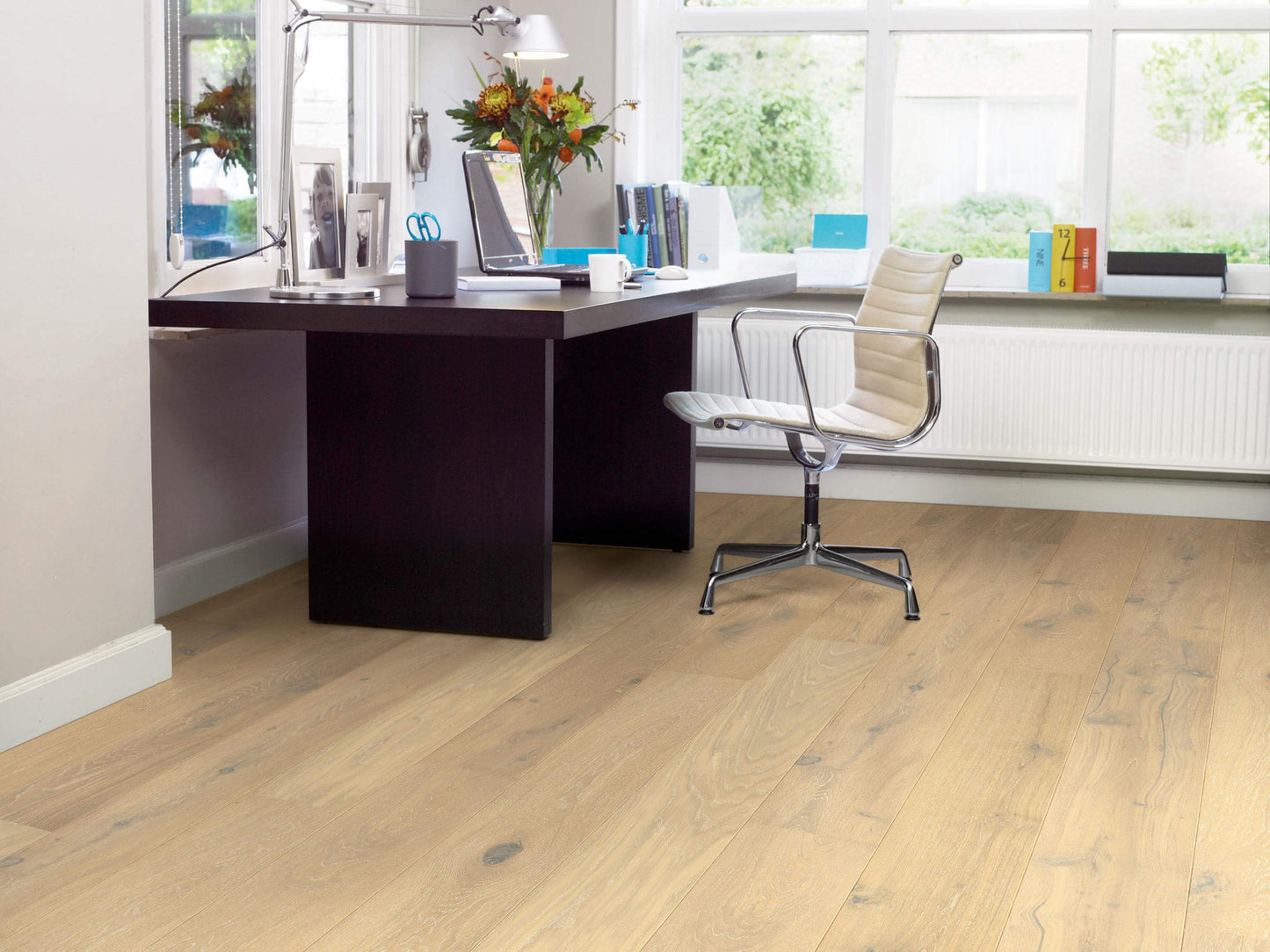 Modern office desk with chair in a bright room with large windows