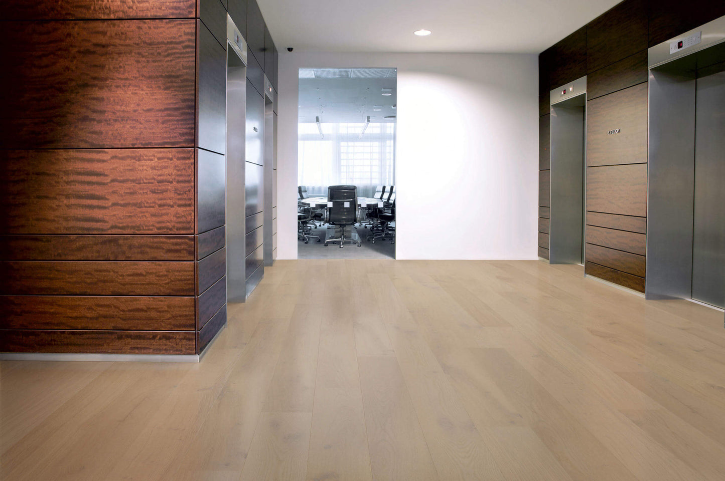 Modern office hallway with wooden and metal elevator doors.
