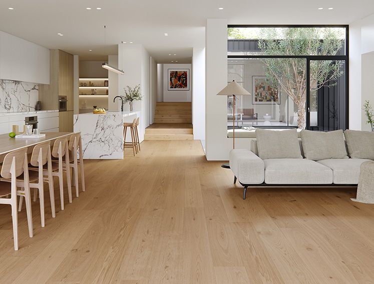 Modern living room with a white sofa, dining table, and kitchen area.