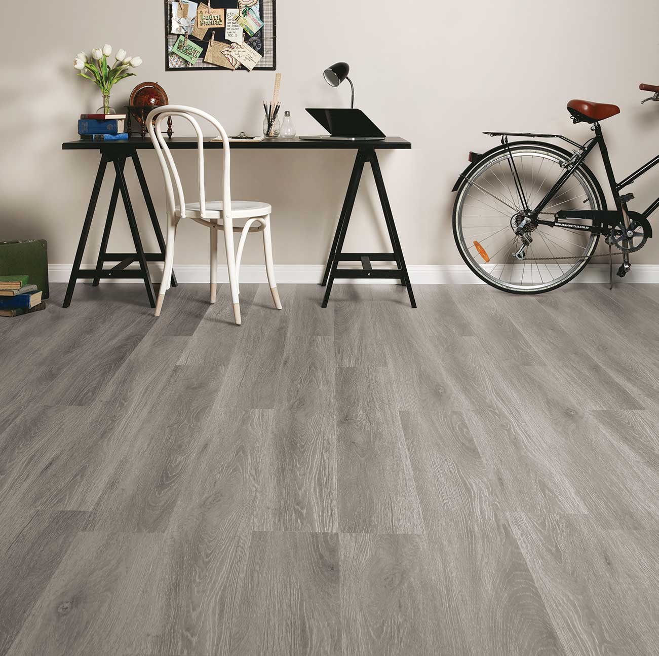 Wooden flooring in a room with a desk, chair, and bicycle.