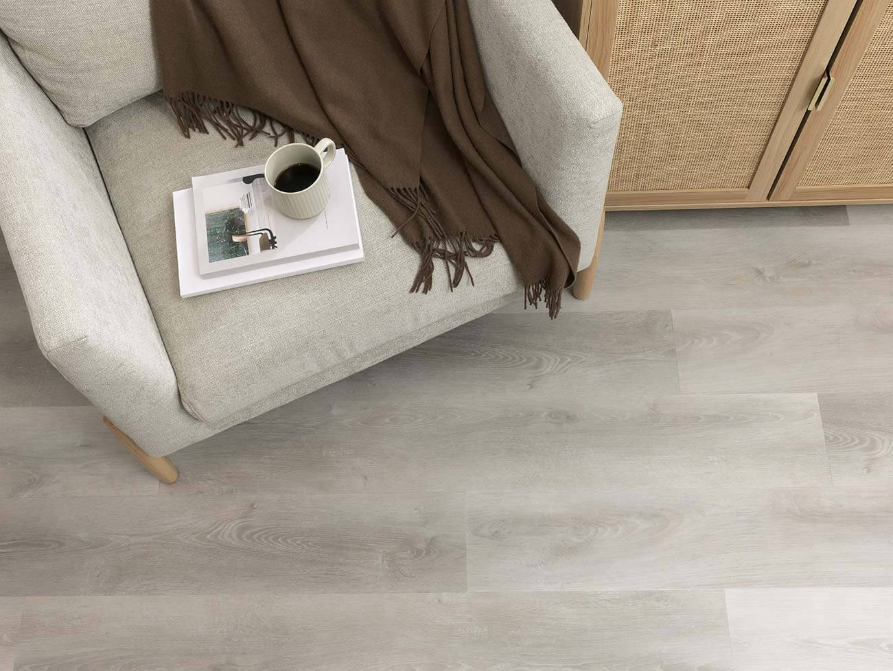 Gray vinyl flooring in a living room setting with a sofa and coffee cup.