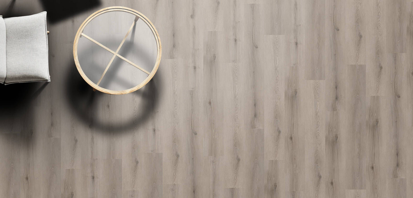 Wooden floor with a round mirror reflecting a chair.
