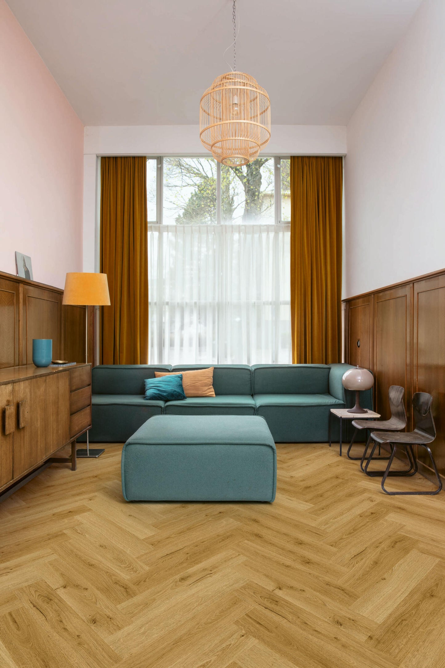 Modern living room with teal sectional sofa, wooden floor, and large window.