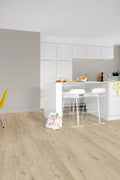 Modern kitchen with light wood flooring and white cabinets.