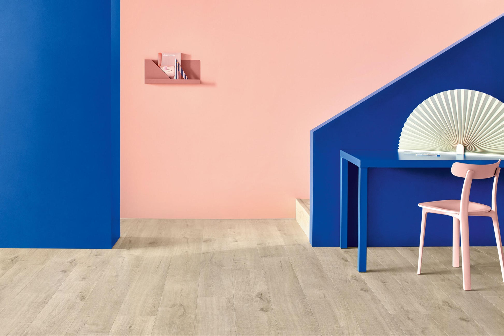 Modern interior design with pink and blue walls, a desk, and chair.