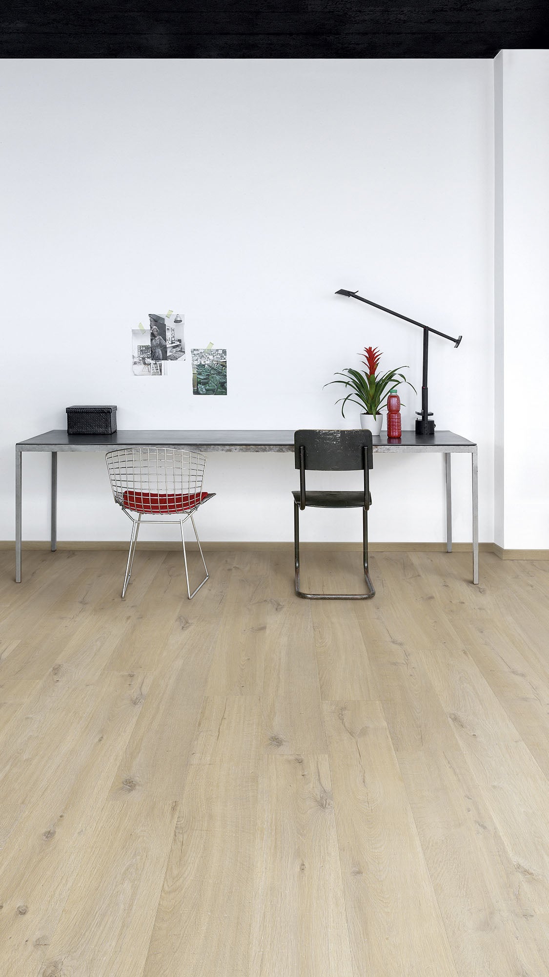Modern office setup with a desk, chairs, and decor on a light wood floor.