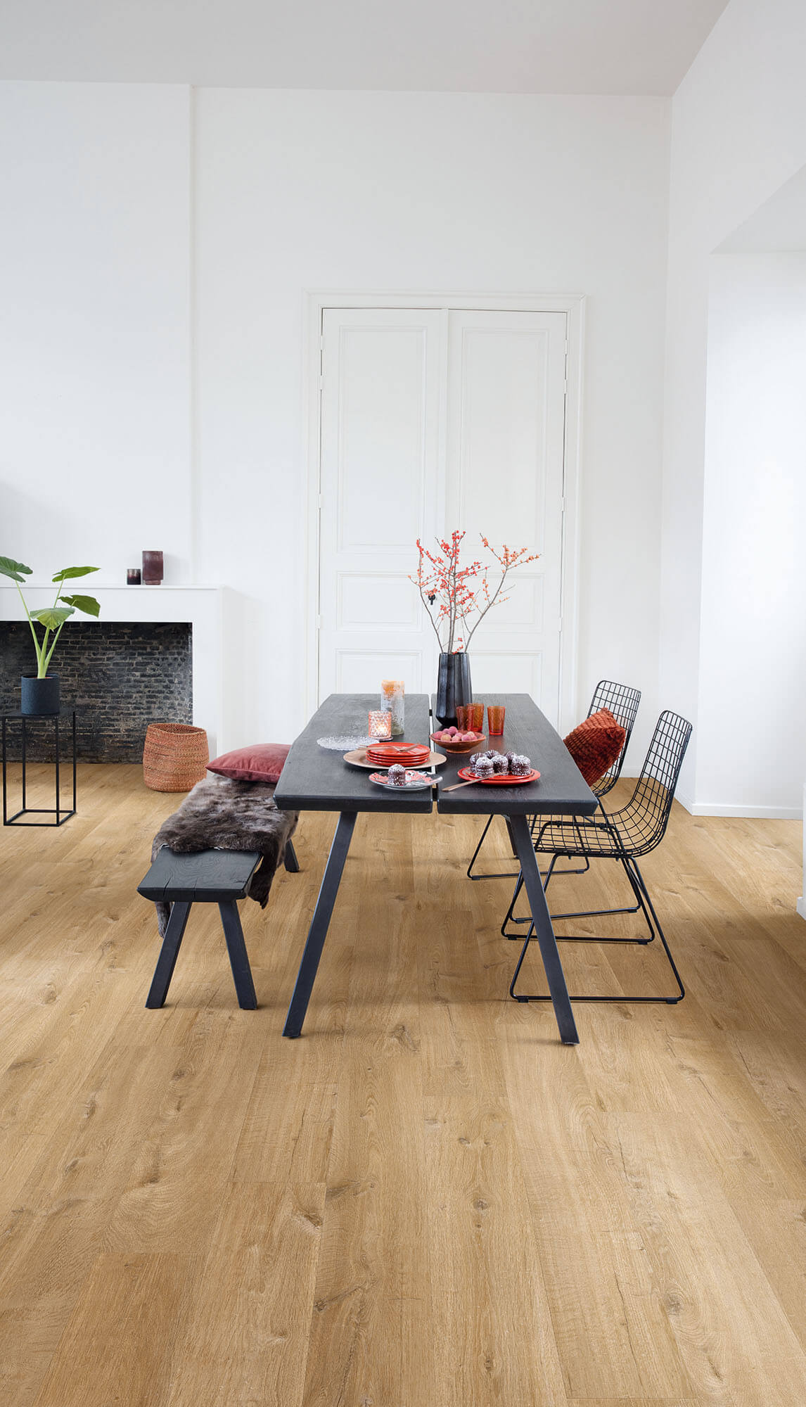Modern dining area with a black table and chairs on a wooden floor.