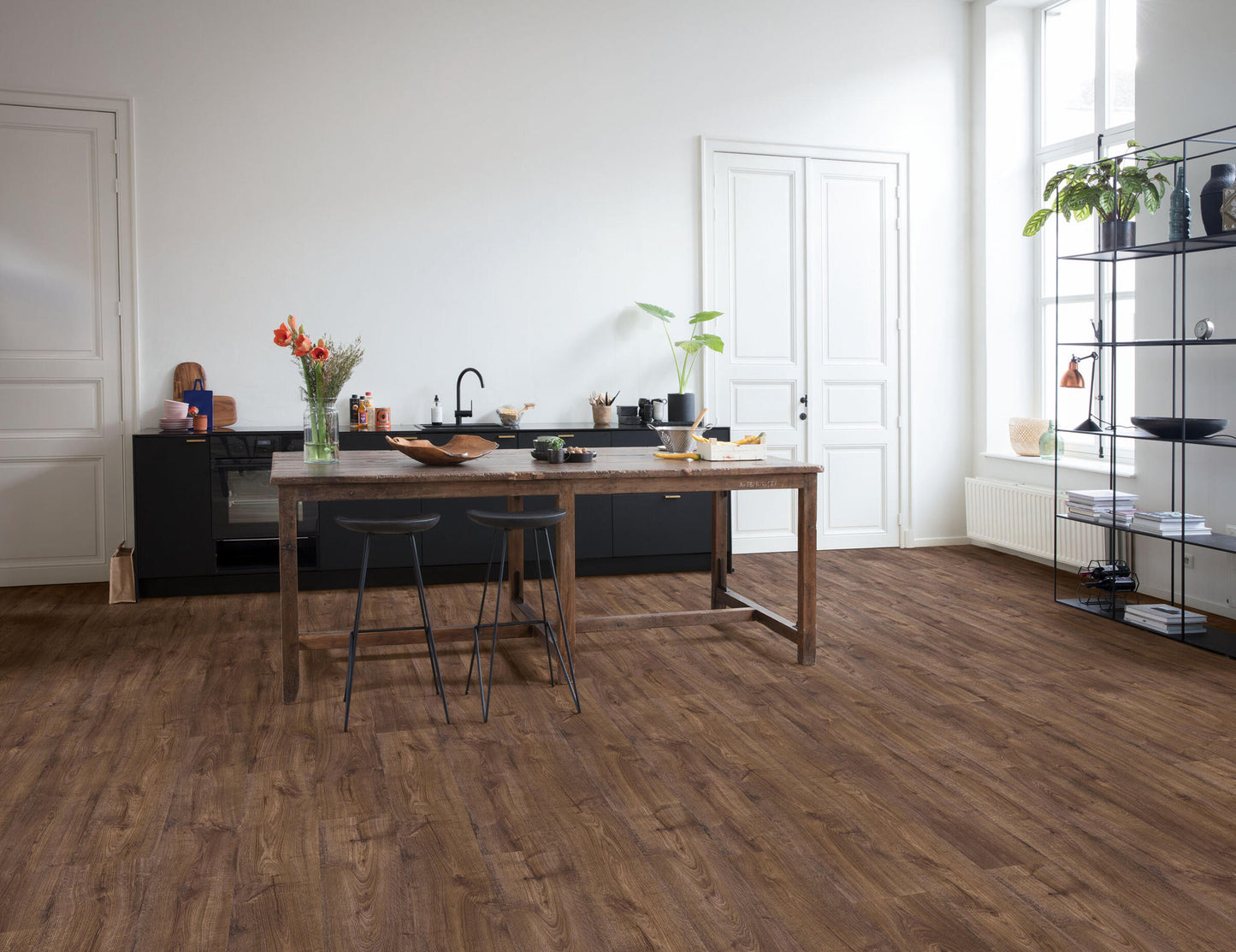 Modern kitchen with wooden dining table and chairs on a wooden floor.