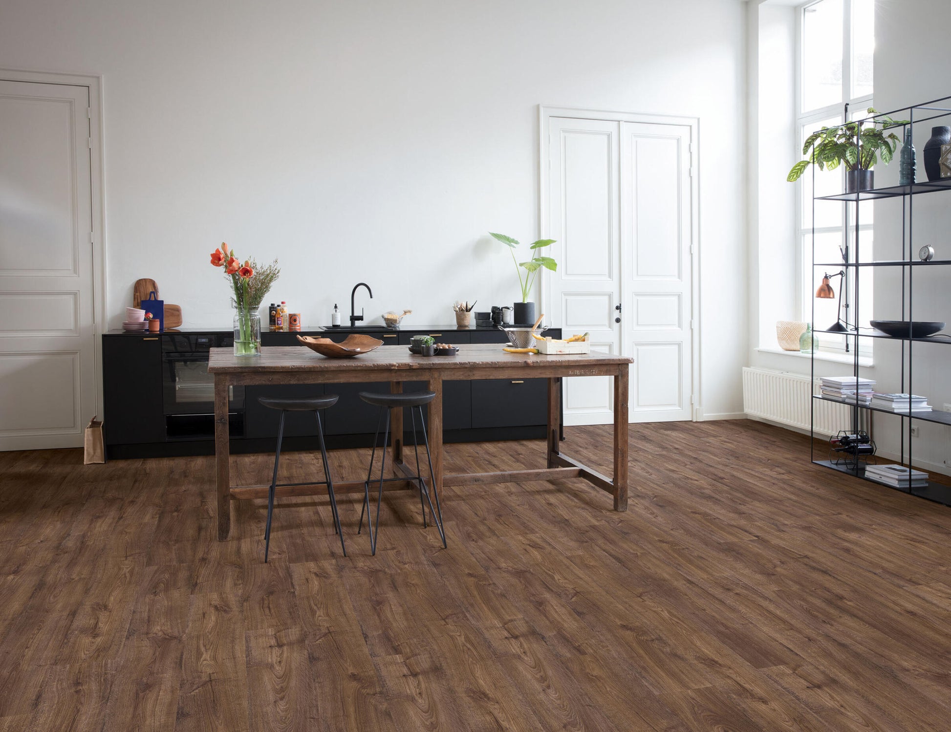 Modern kitchen with wooden dining table and chairs on a wooden floor.