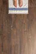 Wooden floor with a rug and feet on it
