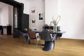 Modern dining room with a black dining table and chairs on a wooden floor.