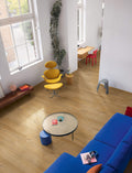 Modern living room with a blue sofa, yellow chair, and round coffee table.