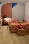 Bedroom with a colorful wall, bed, nightstands, and decor items.