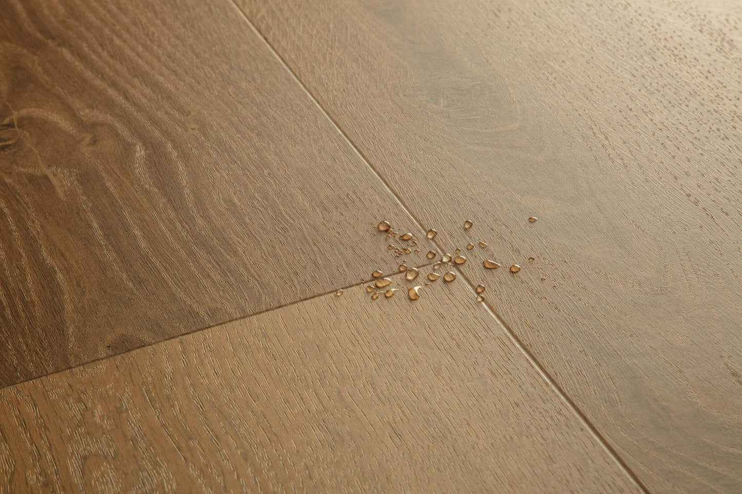 Wooden floor with a small cluster of gold beads on it