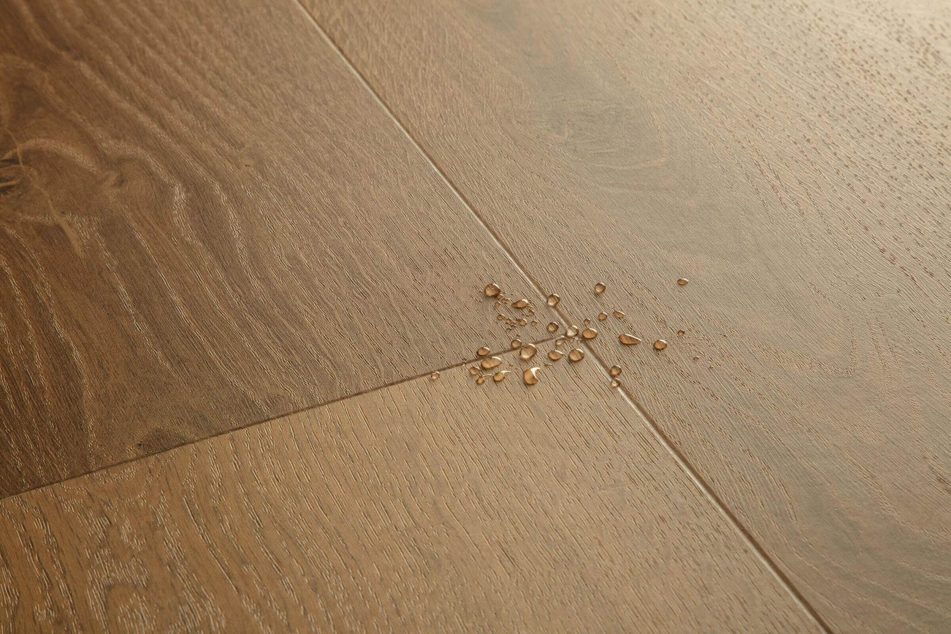 Wooden floor with a small cluster of gold beads on it