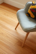 Gray chair with a colorful pillow on a wooden floor