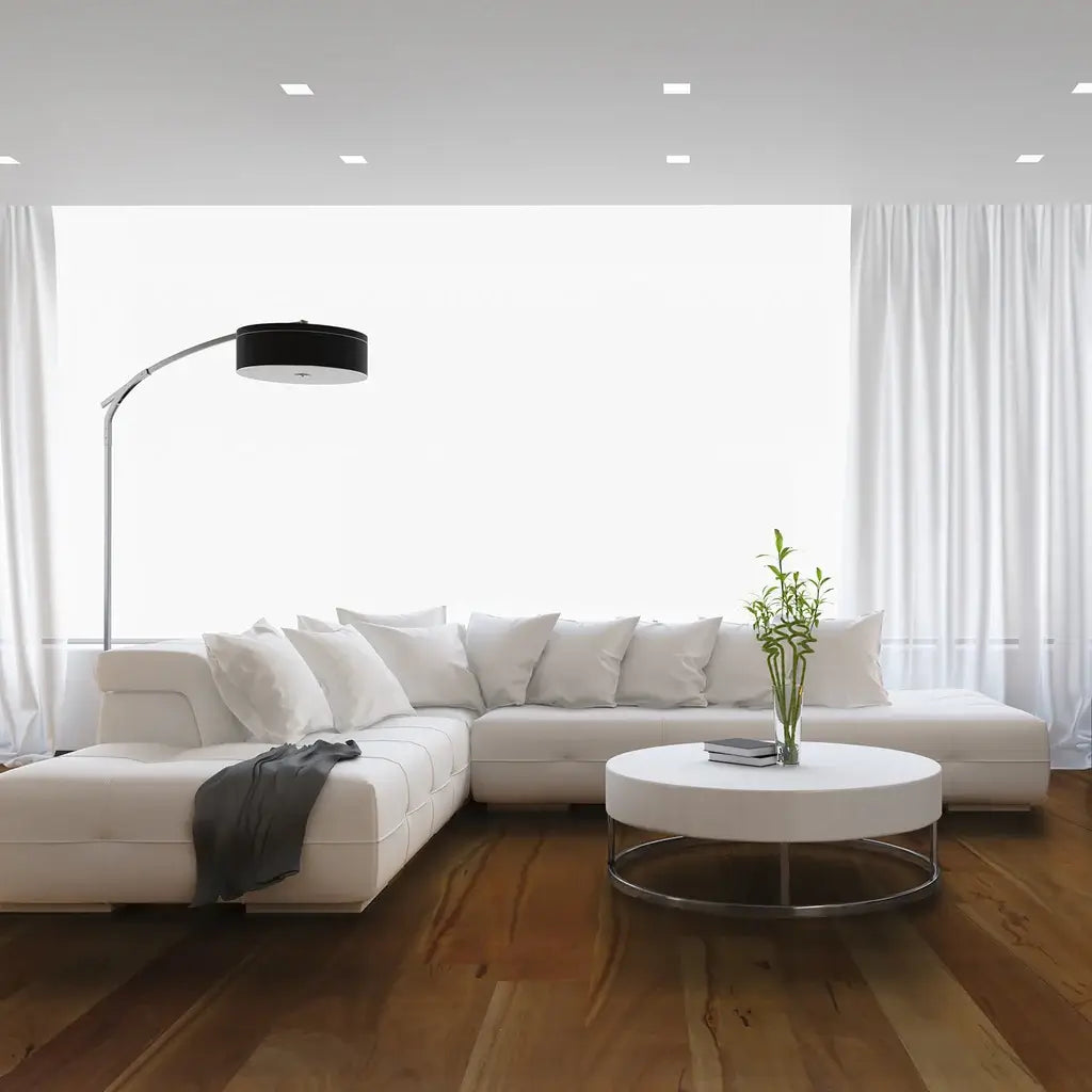 Modern living room with a white sectional sofa, coffee table, and decorative lamp.