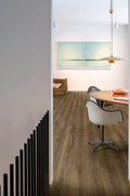 Modern interior with wooden flooring, white chair, and abstract painting on the wall.