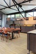 Modern kitchen with wooden dining table and chairs, and a kitchen island.