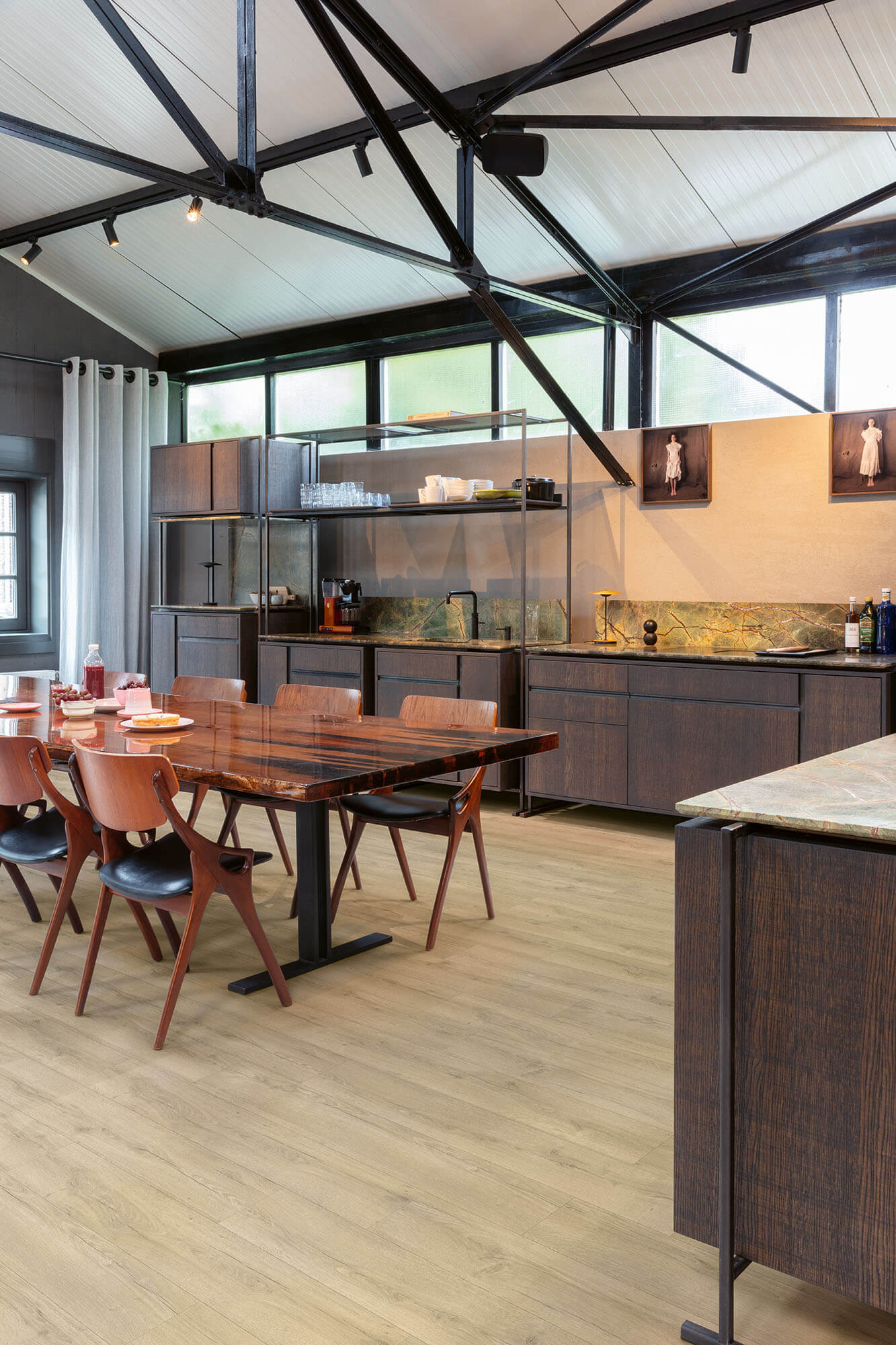 Modern kitchen with wooden dining table and chairs, and a kitchen island.