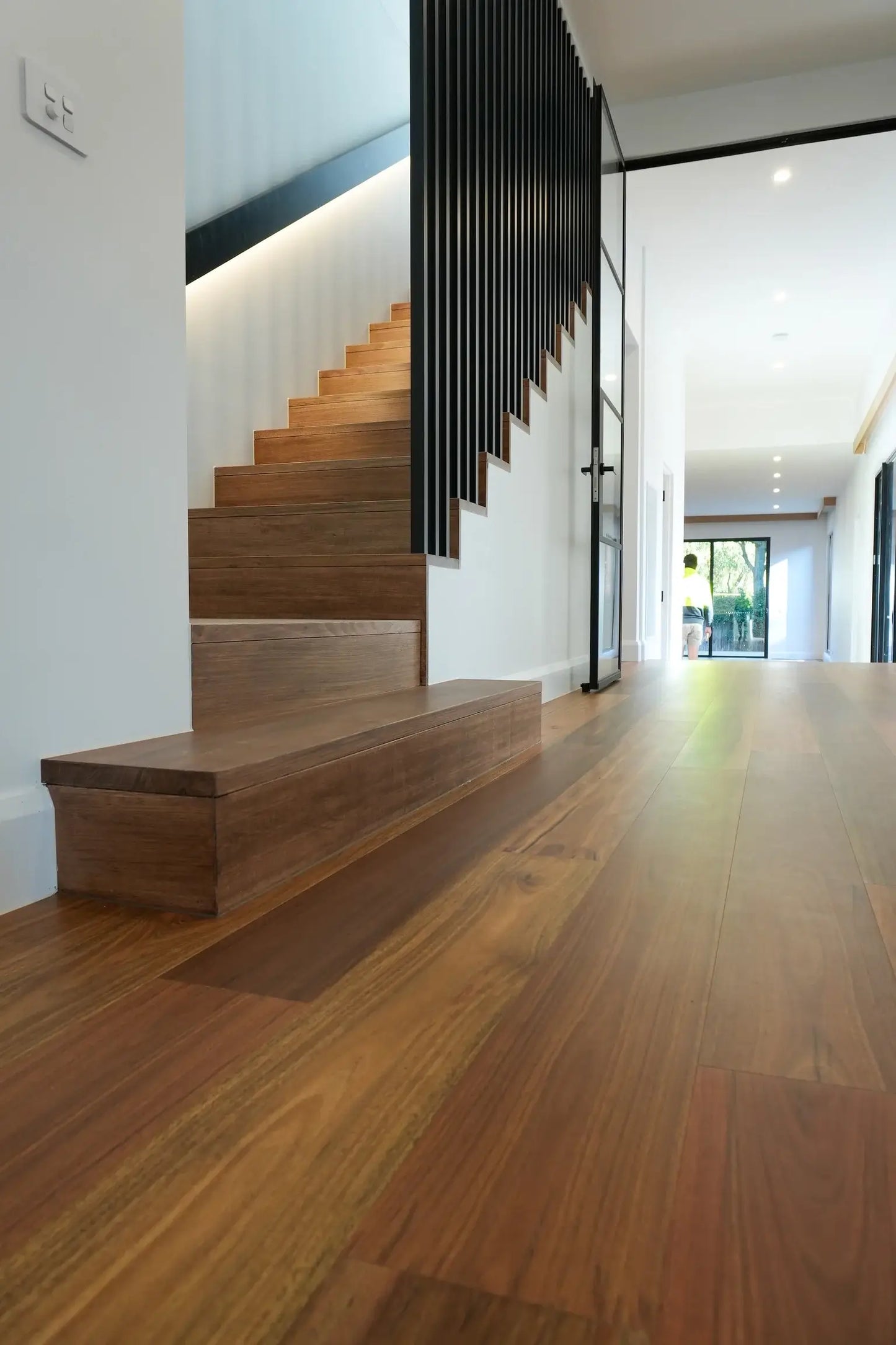 Modern staircase with wooden steps and a sleek design in a well-lit room.