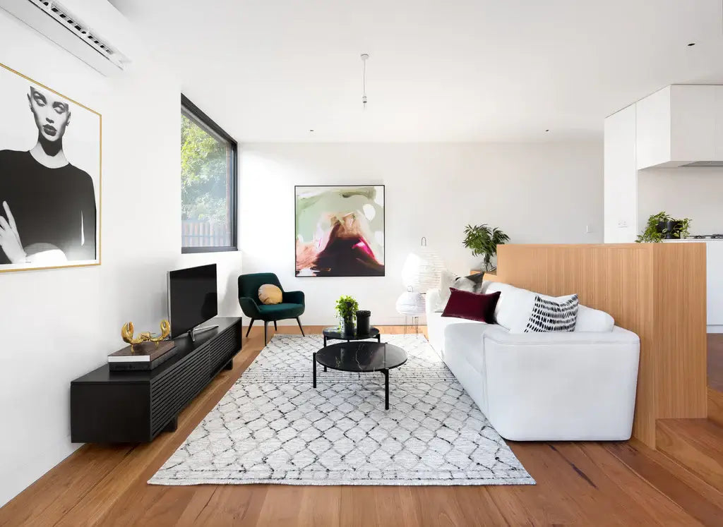 Modern living room with white sofa, coffee table, and decorative items.
