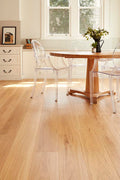 Dining room with wooden floor, table, and chairs.