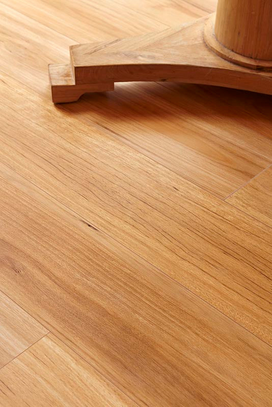Close-up of a wooden floor with a piece of furniture partially visible