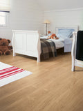 Children's bedroom with white sleigh bed, teddy bears, and wooden flooring.