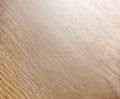 Close-up of a wooden surface with a light brown color and visible grain.