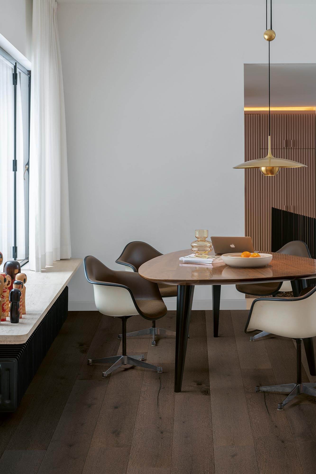 Modern dining area with a wooden table and chairs in a well-lit room.