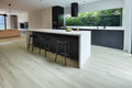 Modern kitchen with a white island and black bar stools.
