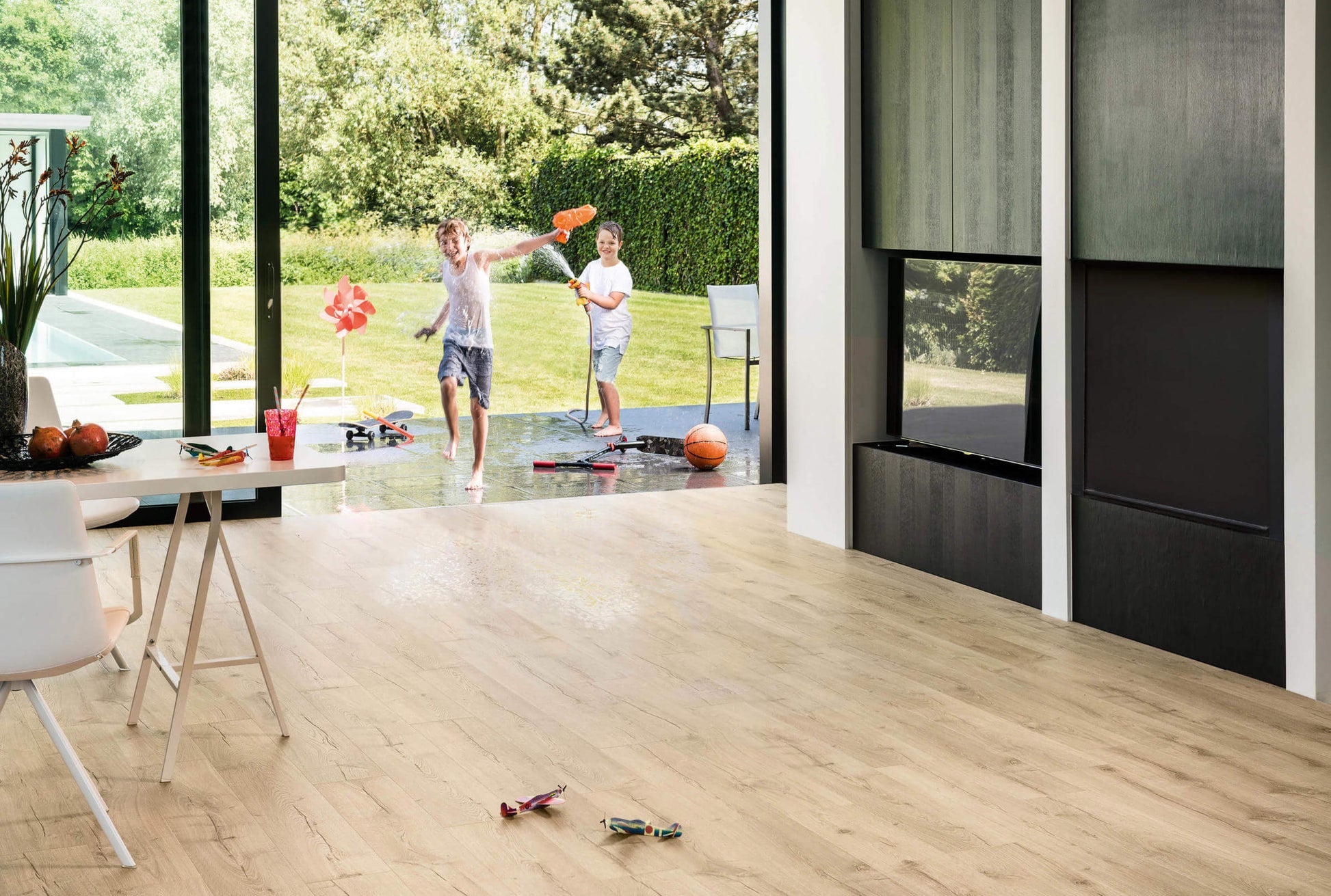 Living room with a large TV and children playing outside