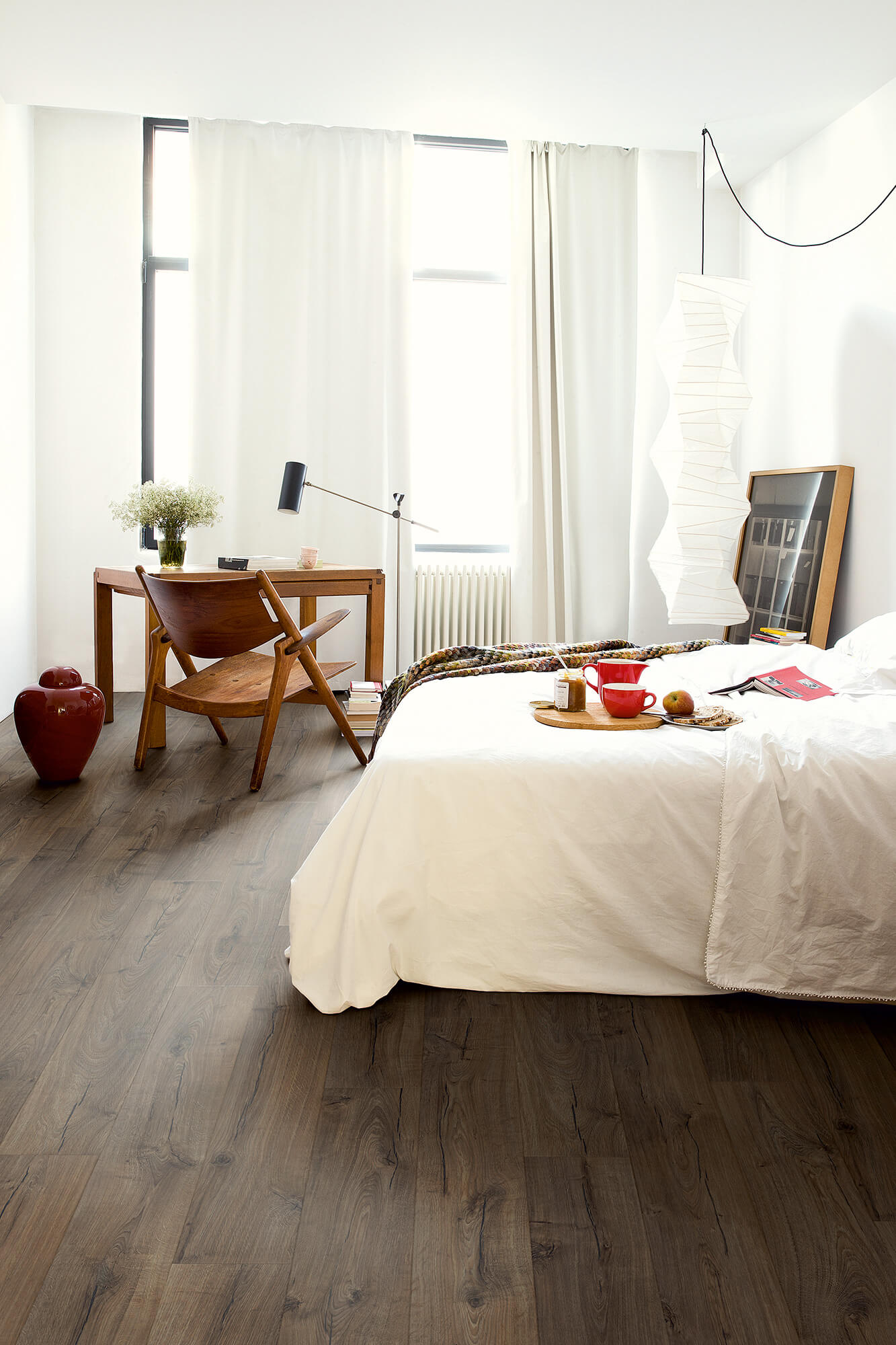 Modern bedroom with a bed, desk, and window